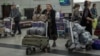 Turkmenistan. People, including passengers of a flight from the Turkmen capital Ashgabat, gather in the baggage claim area upon their arrival at Almaty International Airport