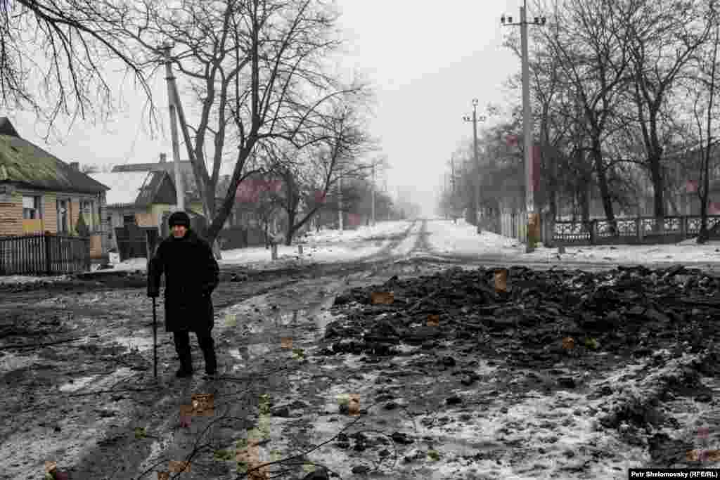 Валентина Павловна - жительница Дебальцево - обходит воронки, оставшиеся после обстрела. Она должна навестить свою больную тетю