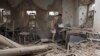 Ukraine -- A woman stands on debris in a destroyed house after recent shelling, on a territory controlled by Ukrainian army, in Sartana village, near the eastern city of Mariupol, August 17, 2015